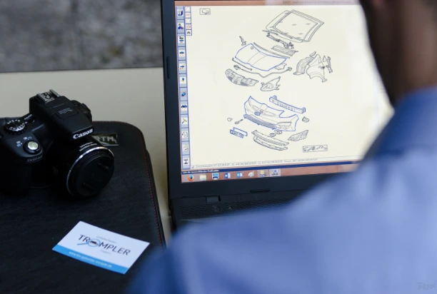 Nahaufnahme der Kamera und des Computerbildschirms von Kfz-Gutachter Anastasio Trompler, während er auf dem PC Fahrzeugteile für die Erstellung eines Gutachtens analysiert.